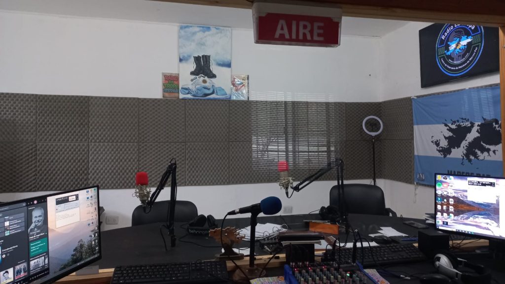Estudio principal de la Cooperativa Radio La Tropa con micrófonos, computadoras y la bandera de las Islas Malvinas.